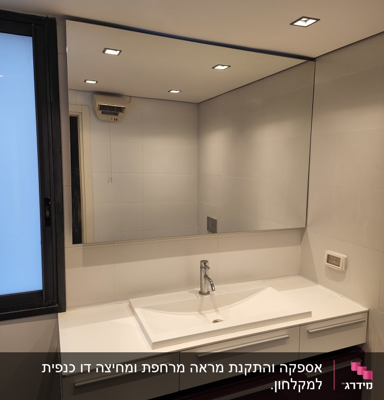 מראה גדולה מעל כיור בחדר אמבטיה מודרני